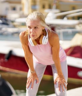 Mature sportswoman takes a break from running