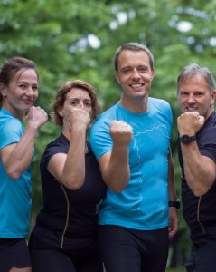 mature runners show strength by raising their fists to the camera